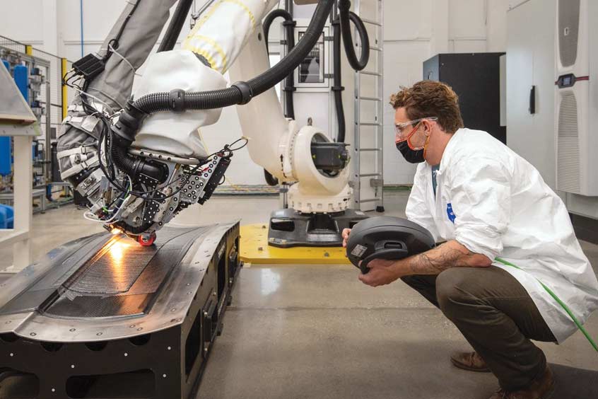 In a Joby Aviation composites lab an automated fibre placement (AFP) machine applies composite material used to fabricate aircraft parts.