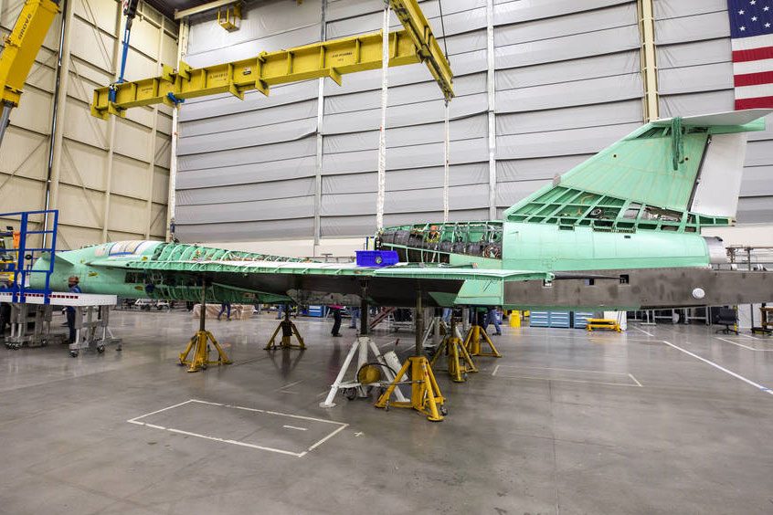 A view of the X-59 being supported by ground supports in preparation for installation of the landing gear and other hardware required for structural testing.