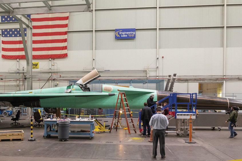 This panoramic side view of NASA’s X-59 Quiet SuperSonic Technology airplane shows the aircraft sitting on jacks at a Lockheed Martin test facility in Fort Worth, Texas.