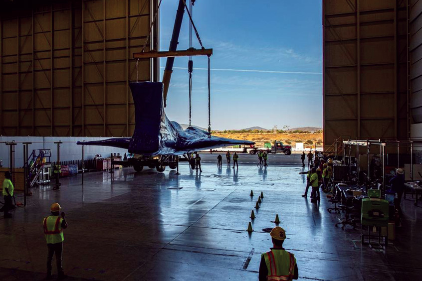 The X-59 is lowered to the ground at Lockheed Martin’s Skunk Works facility in Palmdale, California following a crane operation to remove it from the back of its transport.