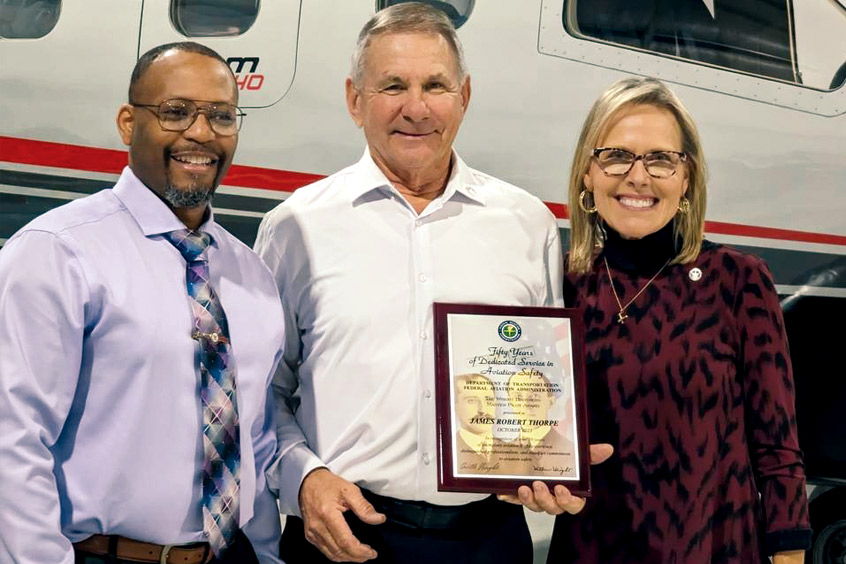 D’Wayne Collins, the FAA safety team program manager at the agency’s Chicago FSDO, presents the Wright Brothers Master Pilot Award to James Thorpe, who is accompanied by his wife Jean.