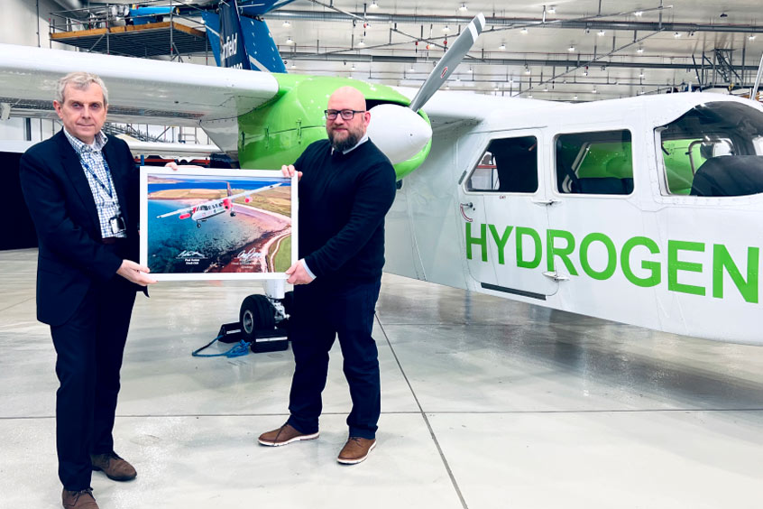 CAeS CEO Paul Hutton and Loganair head of sustainability strategy Andy Smith with a render of the hydrogen-electric Islander.