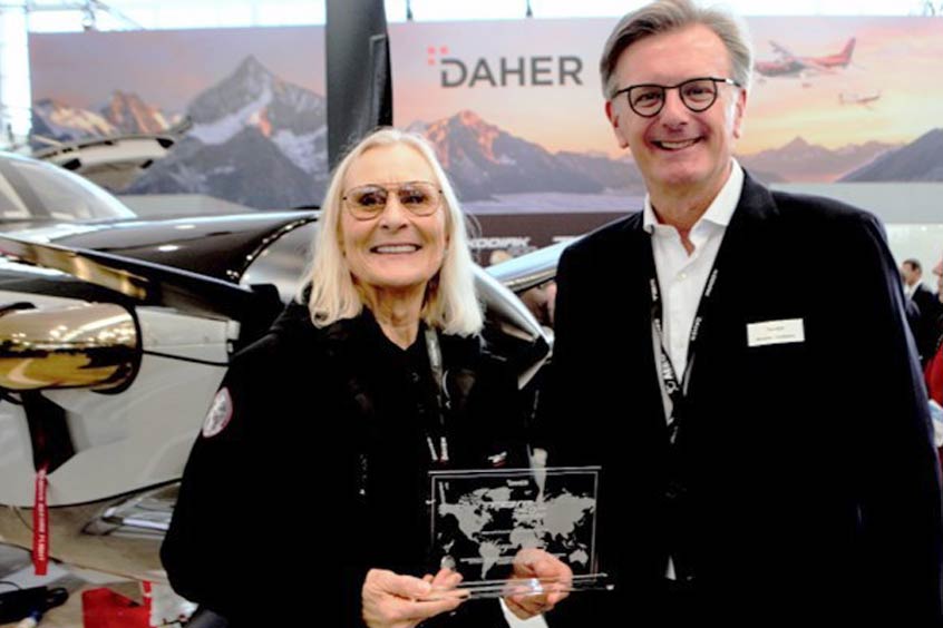 In honour of her 960th ferry flight, legendary ferry pilot Margrit Waltz receives a commemorative plaque and flowers from Nicolas Chabbert, CEO of Daher's Aircraft Division.