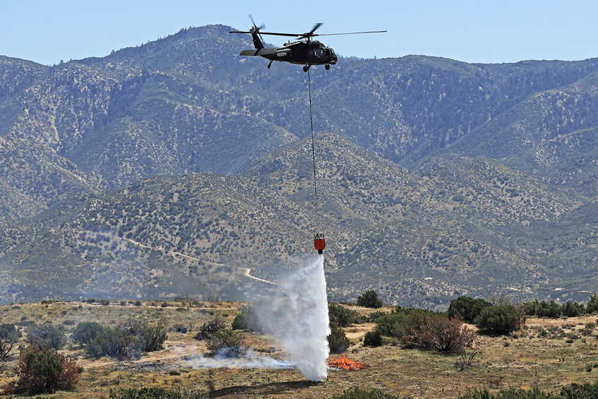 A Black Hawk helicopter equipped with Sikorsky MATRIX and Rain autonomy drops water onto a staged burn in Calif., April 24.
